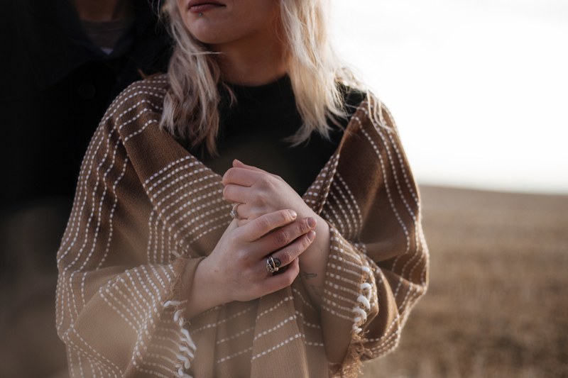 torso of a woman wearing trendy rings and a brown shawl, brown shawl 4k
