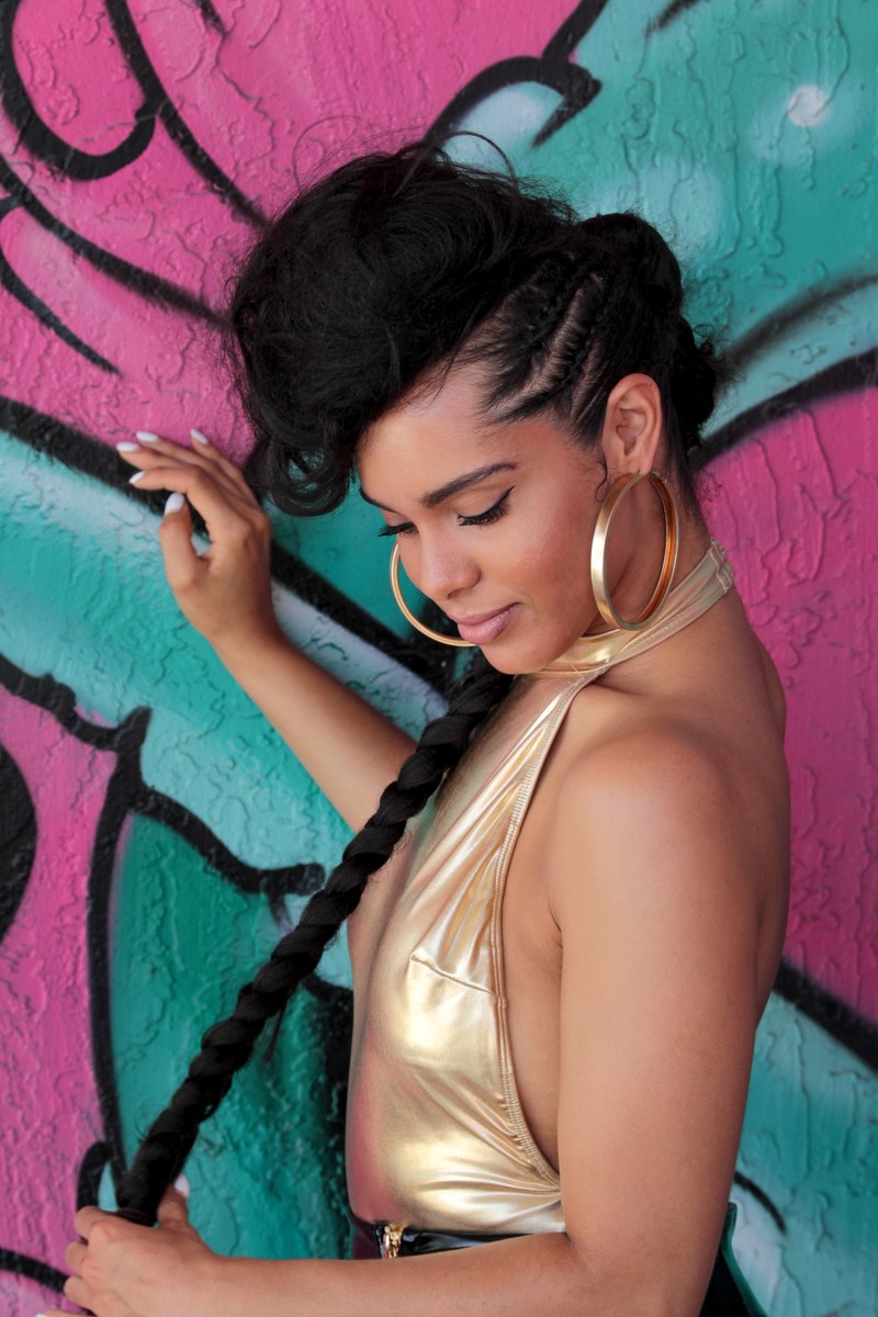 attractive young woman in gold dress and hoop rings posing in front of graffiti street art, woman with braids in front of graffiti 4k
