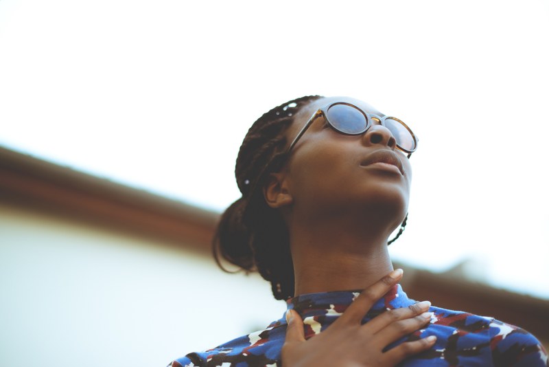 a fashionable young woman in sunglasses and a colorful shirt looking away from a camera, _young woman in sunglasses 4k
