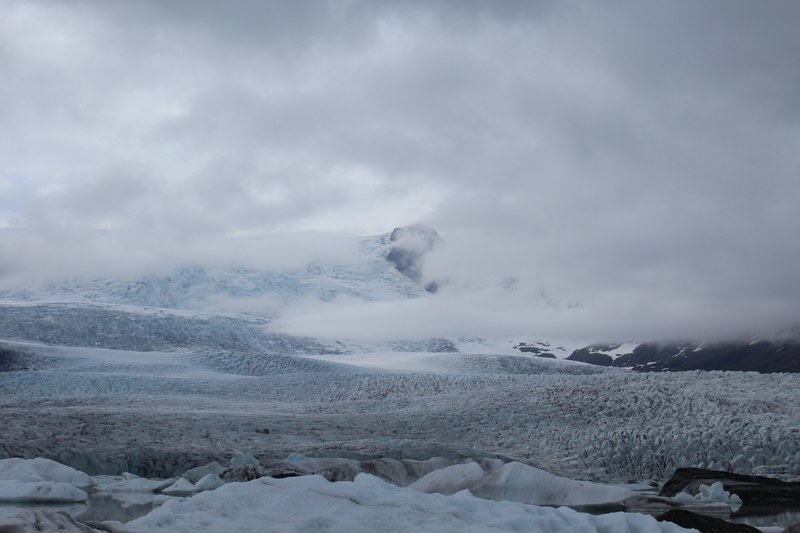 a cloud hangs low over snowy hills in the wilderness, cloudfall over snow 4k