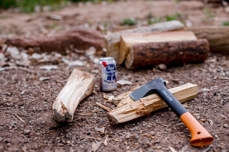 a small axe placed next to chopped wood and a beer can on the ground in watchman campground site b 9, lumberjacks break 4k