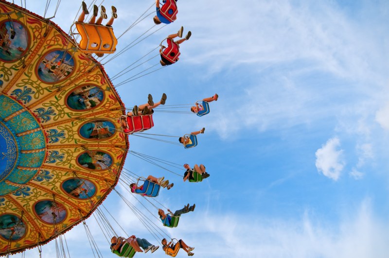 young people and children on a fairground swing ride, fairground swing ride 4k