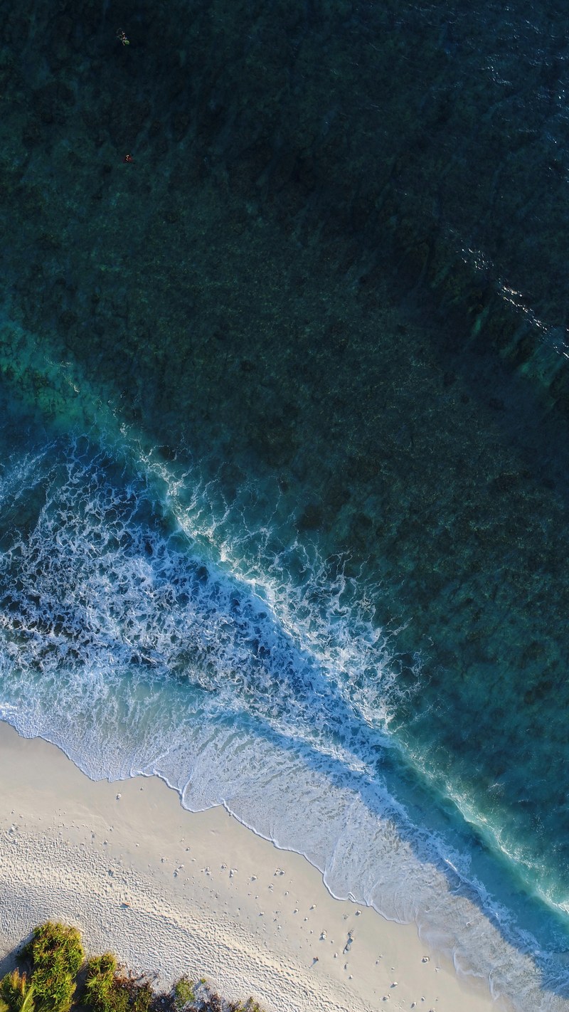 drone aerial view of ocean waves washing on the sand beach at maldives, maldives 4k