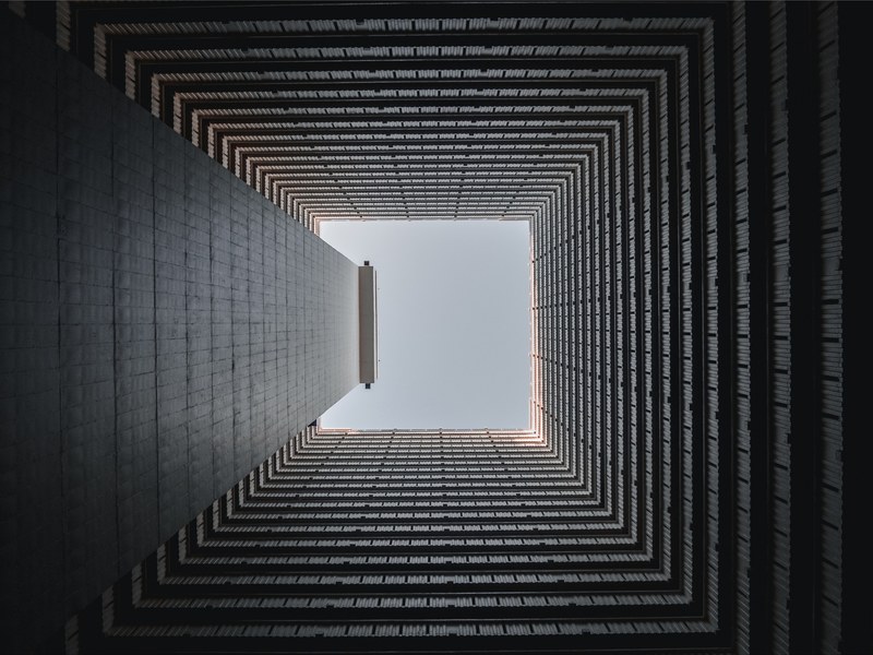 view from the bottom of a square well on the blue sky above, lines 4k