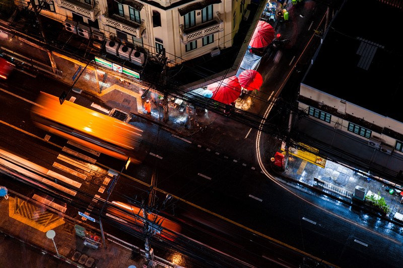 a birds eye view taken by drone showing the quiet night time traffic on a road in bangkok, drone view of bangkok at night 4k