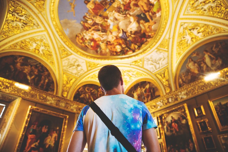 man in multicolored tie dye t shirt looking at ornate religious gold ceiling architecture in florence, man gazes at gold ceiling 4k