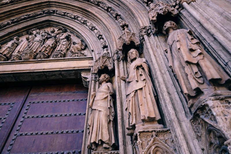 carved statues on the front wall of a church, _gothic church in valencia 4k