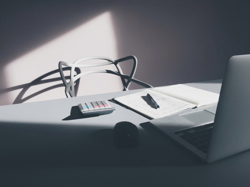 a modern white chair at a table with a laptop a notebook and a calculator, accountant home desk 4k