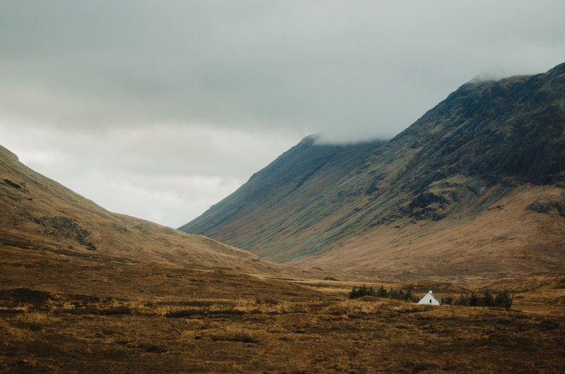 the top of a lone cabin peaks out from the misty mountain highlands in scotland, scotland cabin in the mountains 4k