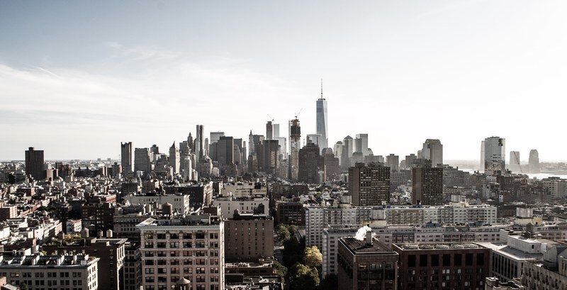 new york citys financial district skyline from a distance against white cloudy skies, find the new world trade center 4k