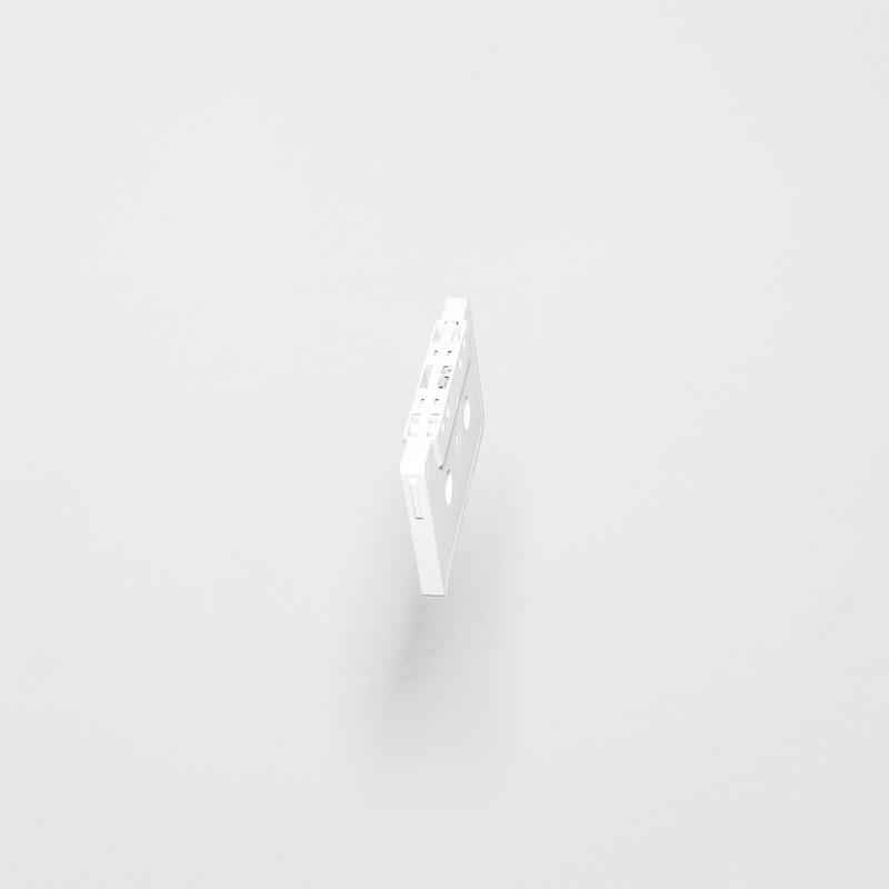 a white cassette tape suspended in the air above a white surface, cassette tape 4k