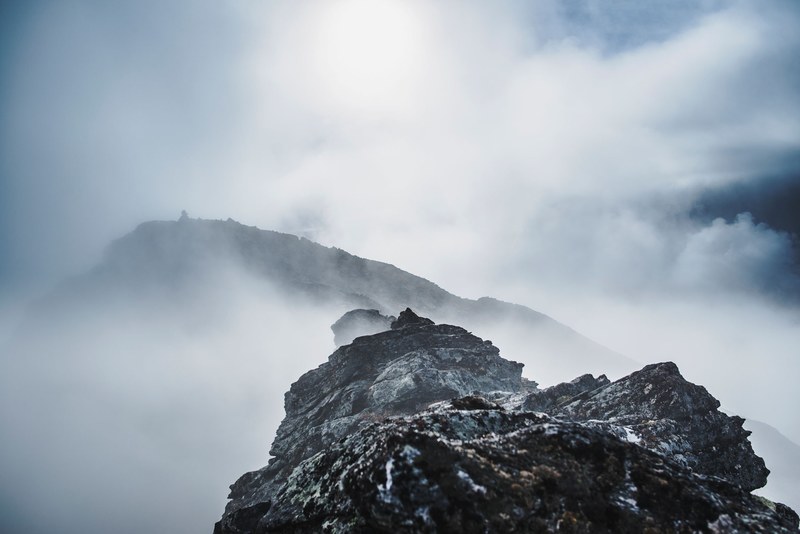 craggy mountain peaks shrouded in fog on a bright day in norway, misty mountains in norway 4k