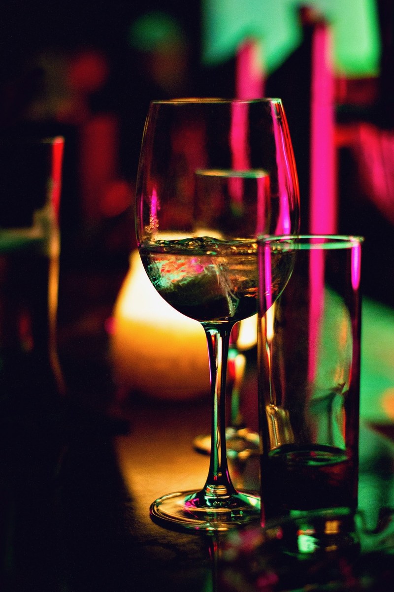 the macro view of wine glasses with alcoholic wine it them in luxembourg city, club lights in glassware 4k