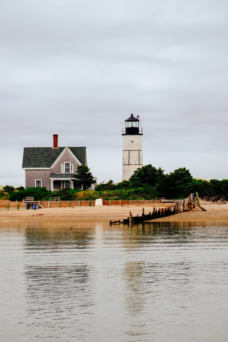lighthouse by the house on a sandy beach at sandy neck, lighthouse 4k