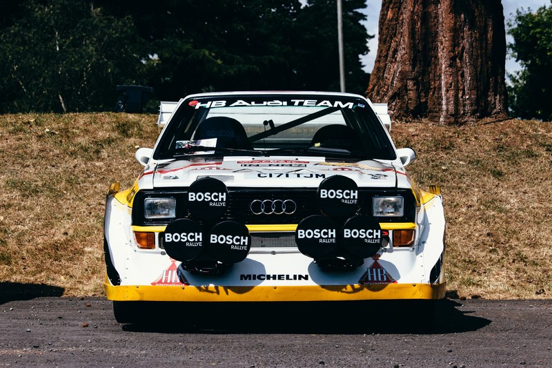race car with bosch logos parked on asphalt near a tree trunk, bosch race car near tree 4k