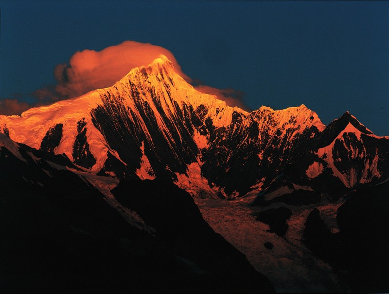 orange sun rays illuminate a snow capped mountain during sunrise, kawakarpo 4k
