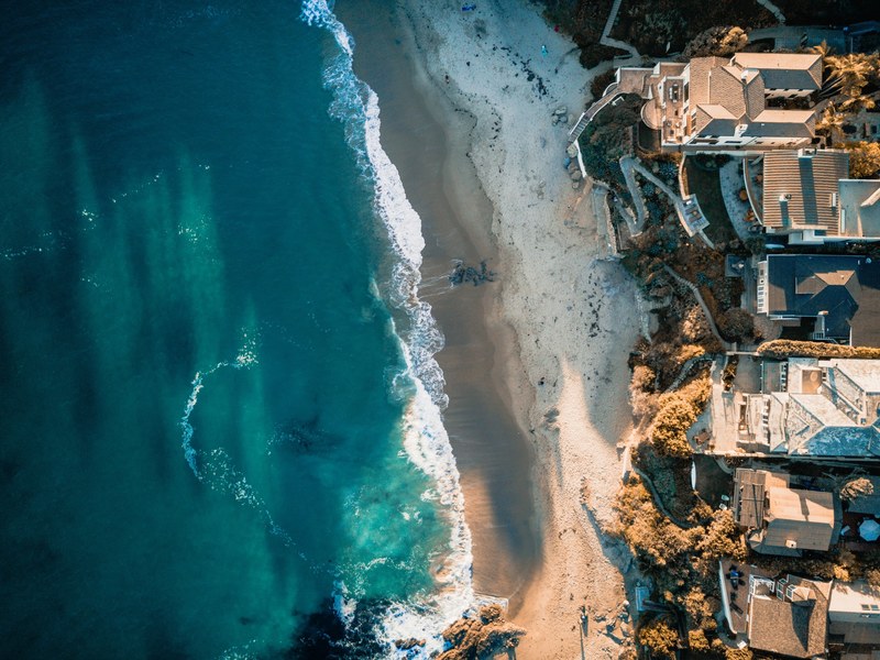 drone aerial view of the ocean sand beach and houses on the laguna beach, drone view of coastal houses 4k