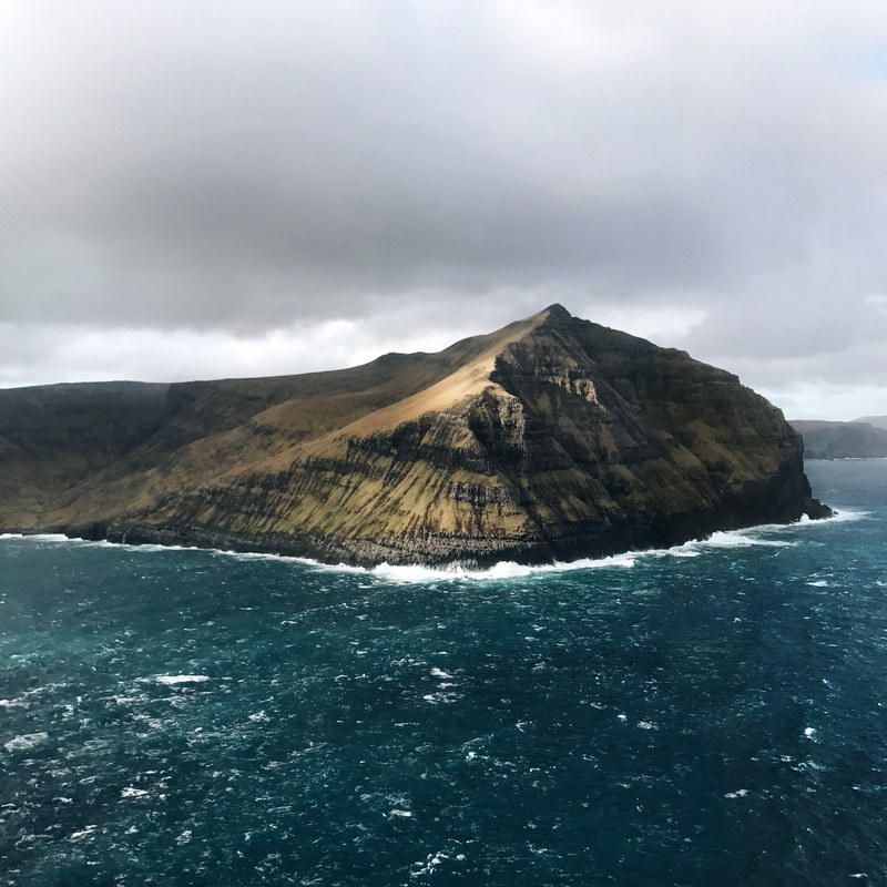 a cliff over choppy azure sea water in the faroe islands, faroe island 4k