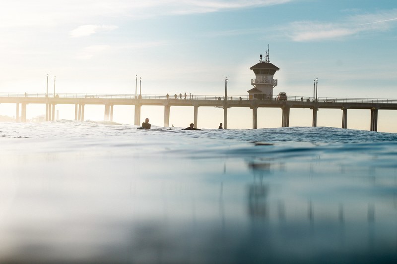 pier and surfers from the water surface at huntington beach, pier viewed from water surface 4k