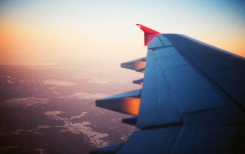 a view from the airplane window on the wing with rural landscape below, flying over the countryside 4k