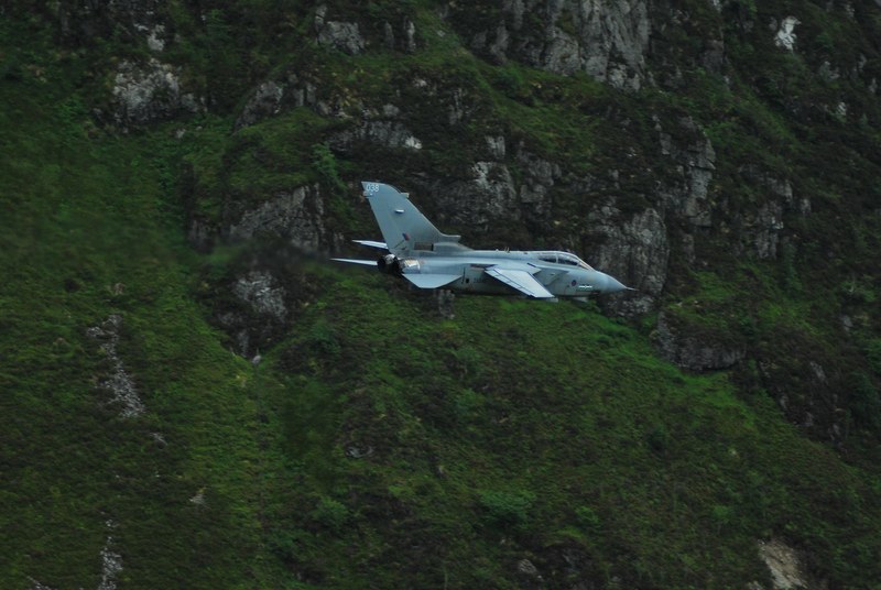 a small plane flies in front of a green mossy mountain, plane with mountain moss 4k