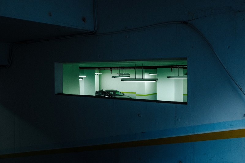 a car is parked in an underground parking garage, _parking garage overhead light 4k