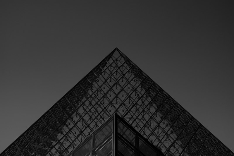 black and white shot of the glass pyramid at louvre museum in paris, pyramid architecture 4k