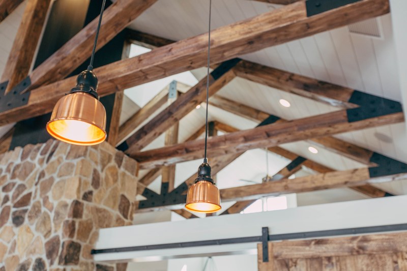 ceiling of a house with wooden beams and rafters exposed and hanging lights between the rafters, rustic house ceiling 4k