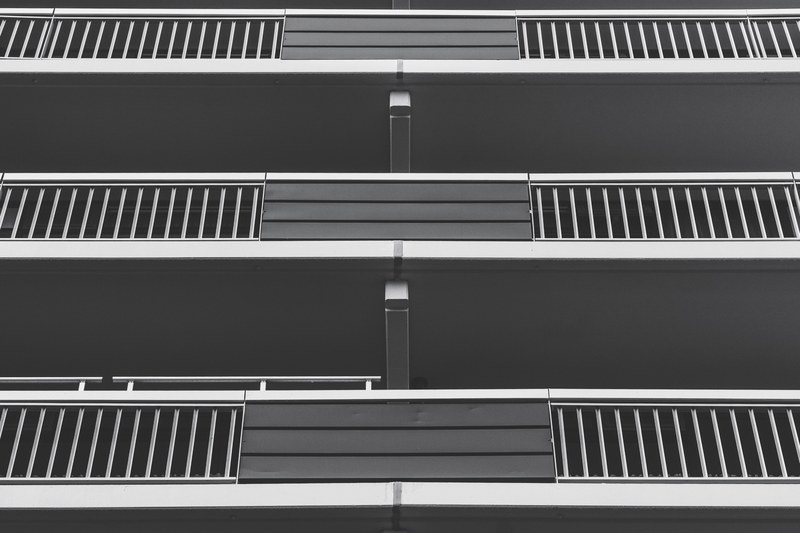 black and white shot of apartment building balconies from below, monochrome flat balconies 4k