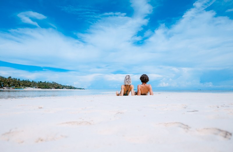 couple enjoys tropical beach with white sands and clear sky, white sands 4k