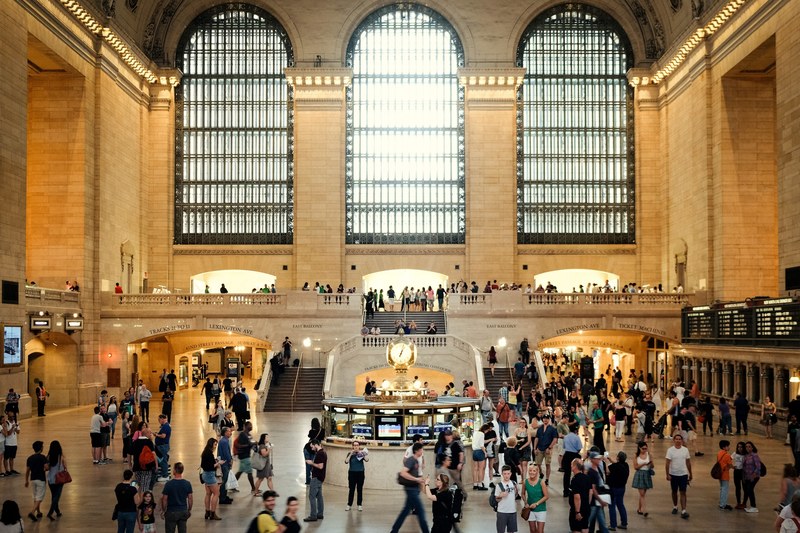commuters at grand central station in front of three large arched windows and a clock, windows of grand central station 4k