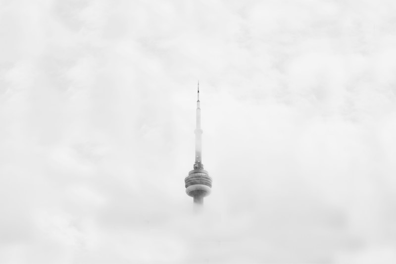 the cn tower in toronto shrouded in thick clouds, cn tower through clouds 4k