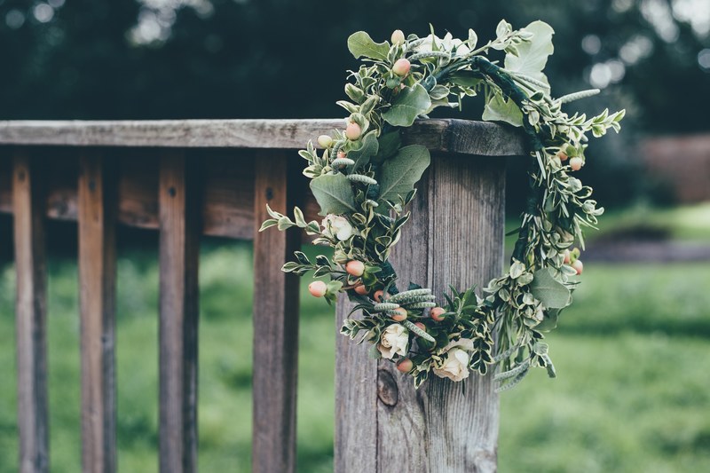 a flower crown hanging from a wooden balustrade, floral wreath 4k