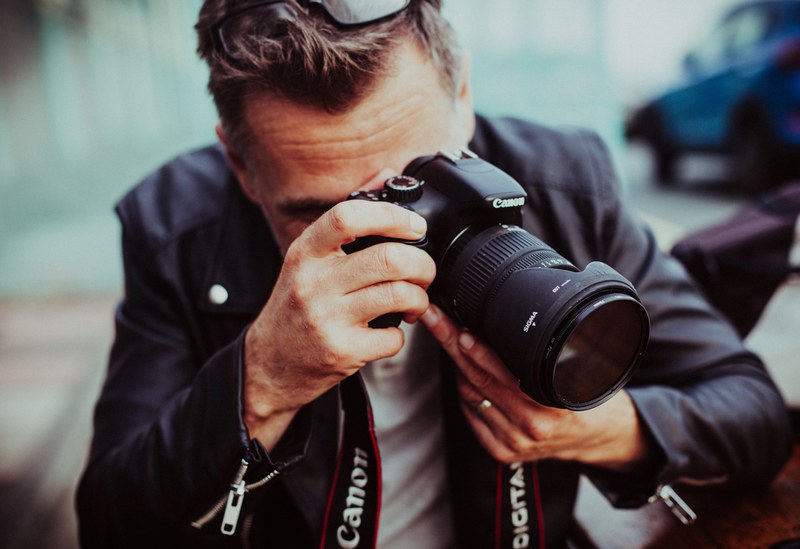 a man taking a photograph with a long lens canon camera, photographer taking a picture 4k