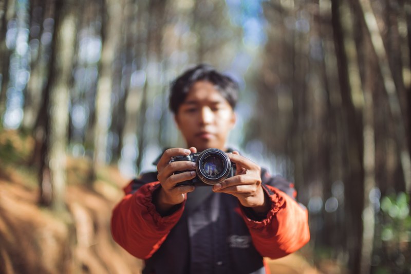 a man wearing a red jacket holding a sony camera, sony camera photos 4k