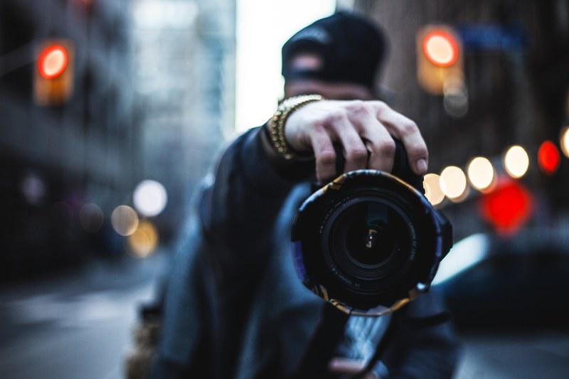 a photographer wearing shiny bracelets and holding a canon camera in toronto, canon camera and bracelets 4k