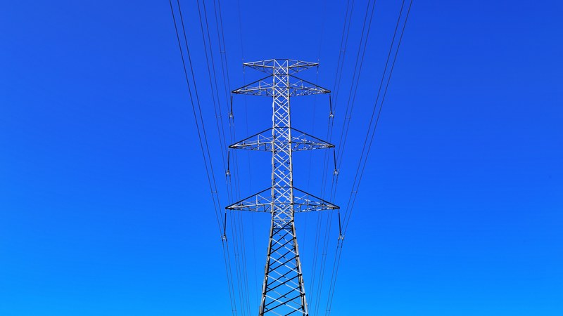 electric tower with power lines creates symmetrical views on a clear blue sky, electrical wires 4k