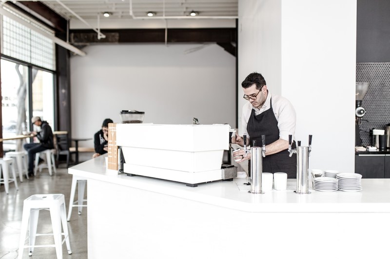 a barista pouring coffee into a cup in a coffee shop, hopper amp burr 4k
