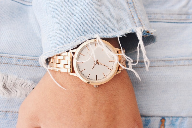 close up of a gold watch on a persons wrist, gold watch denim cuffs 4k