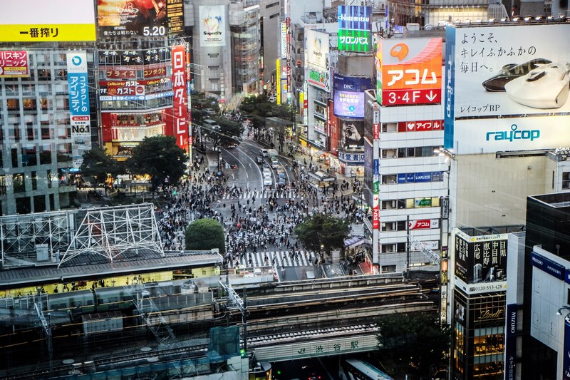 a distant shot of a crowded intersection surrounded by colorful advertisements, ads around an intersection 4k