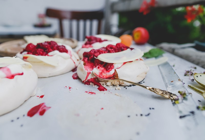 rustic tablescape with french meringue cakes with raspberry sauce for dessert, pavlova 4k