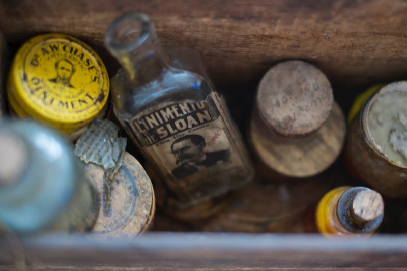 a wooden box filled with vintage medicinal jars and containers, vintage medicinal bottles 4k
