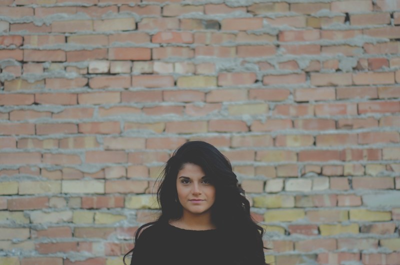 a young brunette woman posing for a portrait near a brick wall, brunette woman near brick wall 4k
