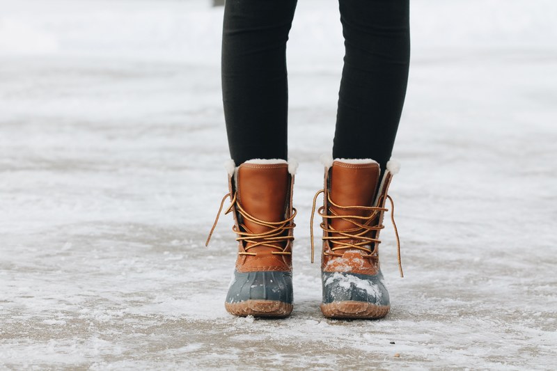 a close up shot of a woman wearing brown boots in spirit lake, snowy tootsies 4k