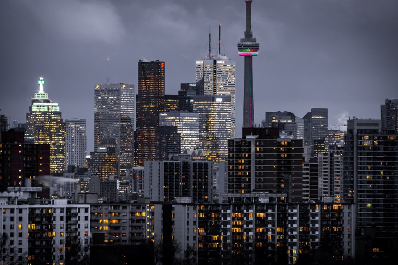 lights in the windows of high rises in toronto on a cloudy evening, yellow life 4k