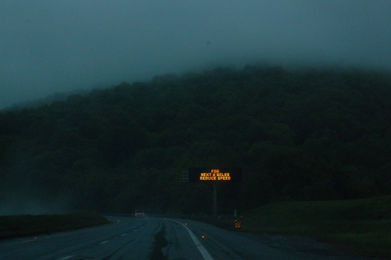 highway sign warns drivers of fog on the road at night, fog on mountain 4k