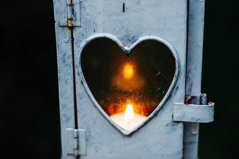 funky metal lantern with a heart shaped window illuminated by candle, glow 4k