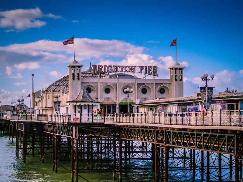 the brighton pier on a beautiful sunny day with blue skies and fluffy clouds, brighton pier 4k