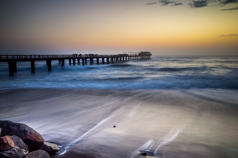 dusk from the beach pier with low waves in swakopmund namibie, namibie beach pier sunset 4k