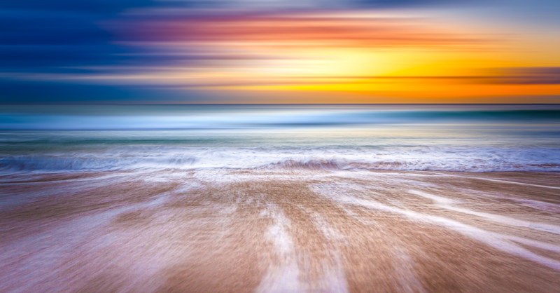 a colorful shot of a blurry shoreline on a sydney beach with a sunset in the horizon, sydney beach waterfront sunset 4k